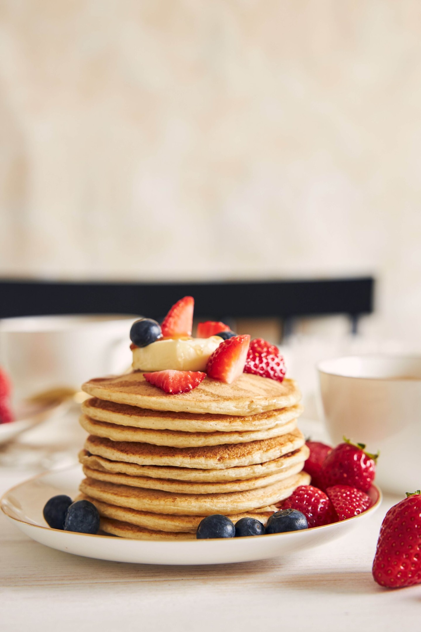 Vertical shot of vegan tofu pancakes with fruits on a white plate