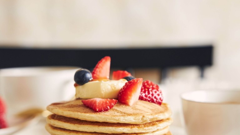 Vertical shot of vegan tofu pancakes with fruits on a white plate